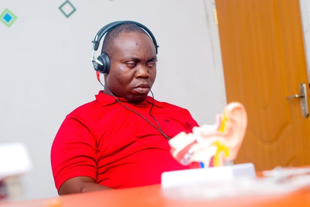 Client during a hearing test with headphones and ear model