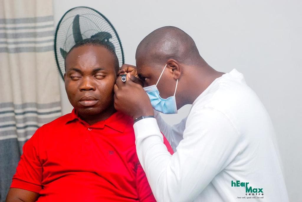 Audiologist examining a client's ear with an otoscope