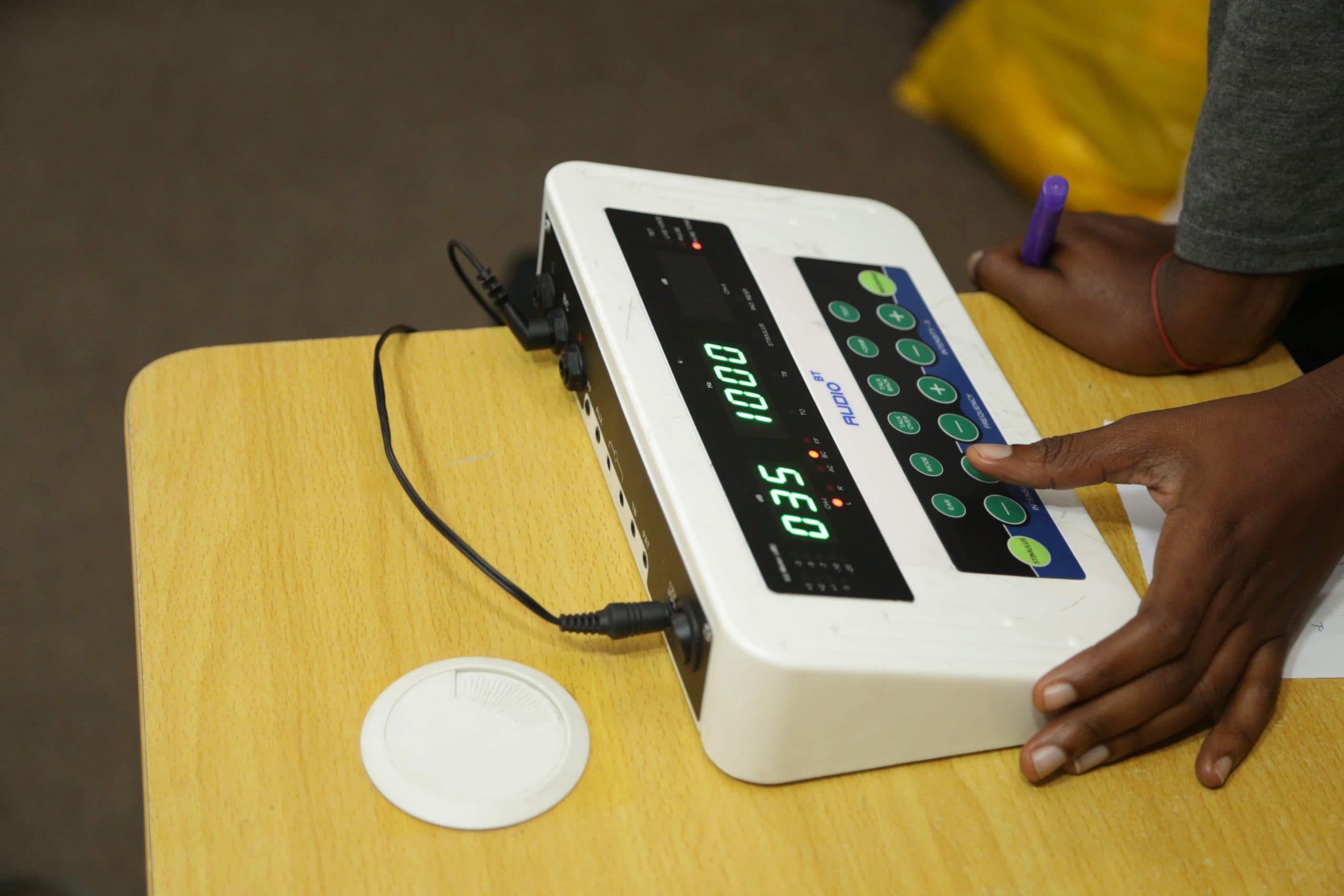 Older adult receiving a hearing assessment with a family member present